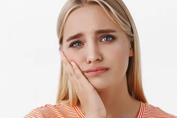 girl holding face with toothache